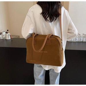 Brown canvas tote bag detail showing life and travel text and adjustable shoulder strap