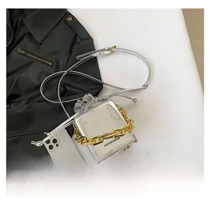 Dettaglio della mini borsa in PU argento con catena dorata e coulisse grigia