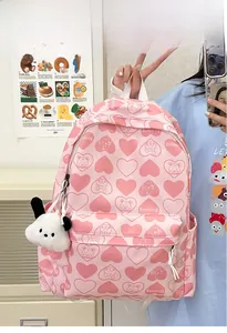 Detail of pink nylon backpack featuring cartoon bear patterns and plush charm accessory