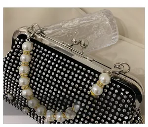 Close-up of sparkling rhinestone handbag featuring premium pearl handle and silver clasp