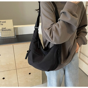 Black nylon crescent dumpling bag with wide shoulder strap and woven zipper pull detail