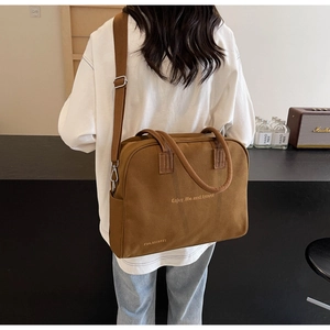 Detail of a brown canvas tote bag with Enjoy life and travel print and adjustable strap