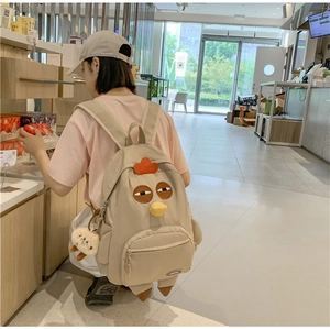 Detailed view of khaki nylon backpack featuring creative cartoon chicken face design