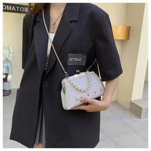 Detailed view of women's sparkling rhinestone handbag with pearl handle and metal chain