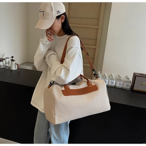 Detail view of large canvas tote bag with brown leather handles and adjustable strap