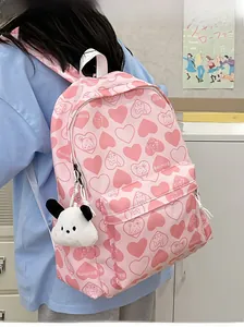 Pink nylon backpack detail with heart bear print and white plush dog keychain