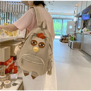 Detail view of beige nylon chick backpack with cartoon features on the side profile