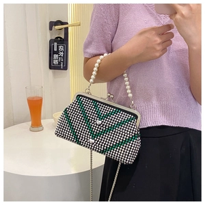 Detail of green and white V-pattern rhinestone handbag with pearl handle and metal strap