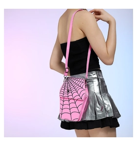 Detail of pink coffin-shaped PU bag with black spider web pattern and adjustable strap