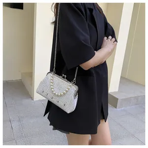 Detailed view of white rhinestone clutch bag with pearl decoration and metal chain strap