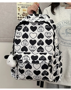 Detail of nylon backpack with black and white heart and bear patterns and side pockets