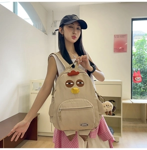 Detail showing creative khaki chicken nylon backpack with cartoon features and logo