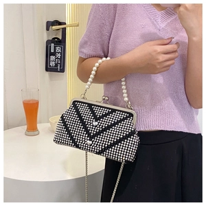 Detail of evening bag with black and white rhinestones, silver heart, and pearl handle