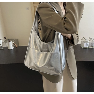 Detail of silver metallic Hobo bag with large capacity and Fashion brand nameplate