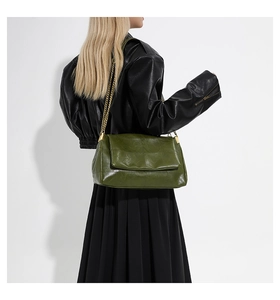 Detail of olive green pleated faux leather shoulder bag with chic gold chain strap