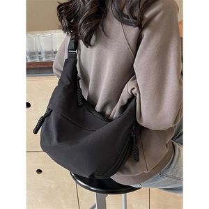 Minimalist black nylon crescent crossbody bag with adjustable strap for casual daily commuting