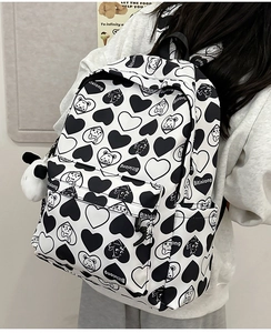 Detail of nylon backpack with panda prints and a plush panda charm in a lifestyle setting