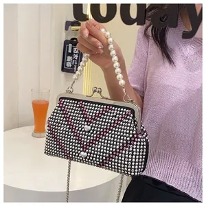 Close-up of sparkling rhinestone evening bag with elegant pearl handle and heart detail
