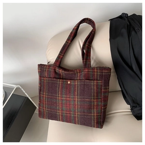 Sac cabas vintage en laine à motif écossais rouge et vert sur un canapé