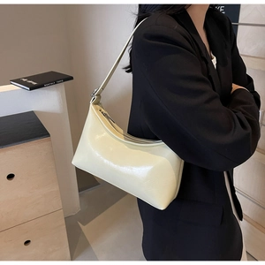Close-up of creamy white glossy PU leather underarm bag featuring a smooth minimalist design