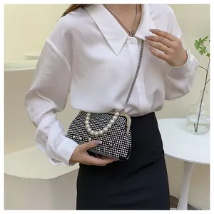 Detail of evening bag featuring sparkling rhinestones, faux pearl handle, and silver chain