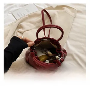 Detailaufnahme des geräumigen Innenraums einer dunkelroten PU-Handtasche mit weiter Öffnung