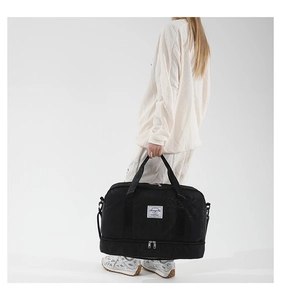 Detail of black star-quilted travel tote with shoe compartment and detachable strap