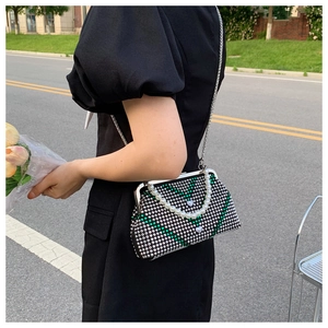 Detailed view of sequined evening bag with pearl handle and silver chain strap