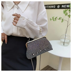 Detail of sparkling rhinestone evening bag with elegant large faux pearl handle