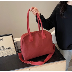 Detail of red fabric tote bag with Enjoy Life and Travel text and reinforced handles