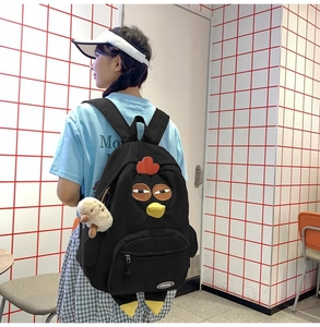Detail of creative cartoon chicken nylon backpack with 3D wings and mushroom pendant