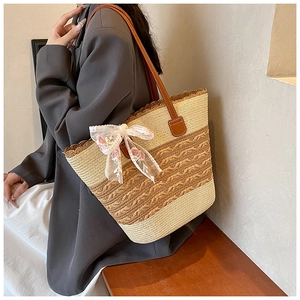 Detail of straw tote bag featuring striped weaving lace trim and floral ribbon accent