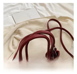 Detail der dunkelroten PU-Handtasche mit Litschistruktur, Silberbeschlägen und Tragegriffen
