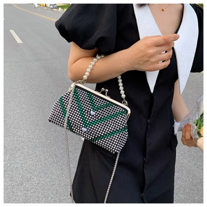 Detail of a sparkling rhinestone crossbody bag with pearl chain and V-pattern design