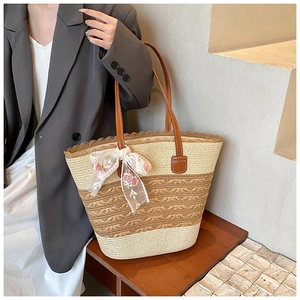 Detailed shot of striped straw woven tote bag with delicate lace floral bow and leather straps