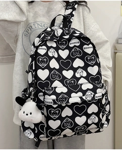 Detail showing bear and heart pattern print on nylon backpack with plush charm