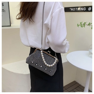 Close-up of black crossbody bag featuring silver rhinestones, pearl handle, and chain strap