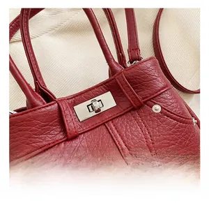 Detailansicht der roten Kunstledertasche mit silbernem Metalldrehverschluss und Nähten