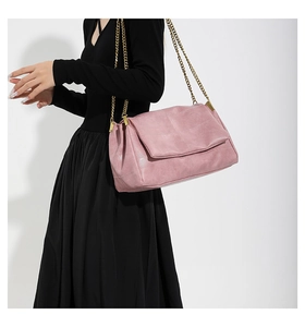 Detailed close-up of pink PU leather shoulder bag with quilted texture and gold chain