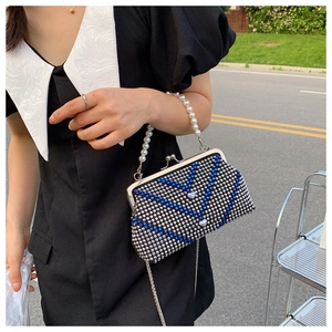 Detail showing silver and blue rhinestone evening bag with love heart charm and pearl handle