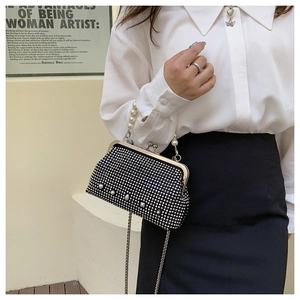 Detail of black rhinestone evening bag featuring large pearls and retro metal clasp