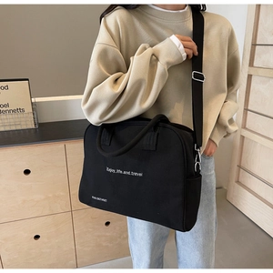 Detail of black canvas tote bag showing Enjoy Life print and adjustable shoulder strap