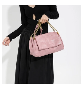 Detail of pink PU leather handbag with quilted stitching and gold chain strap