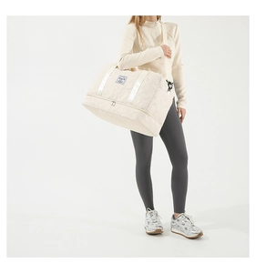 Detailed view of beige quilted travel bag with star pattern and bottom shoe compartment