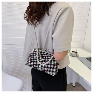 Close-up of evening crossbody bag with pink heart rhinestones and pearl handle
