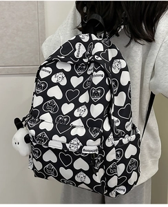 Side view of trendy nylon backpack featuring bear patterns and a cute puppy keychain