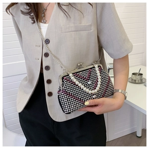 Detail showing shiny rhinestones heart pattern with pearl handle and metal chain