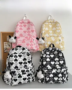 Detail showing four nylon heart backpacks in pink, yellow, white and black with plush charms