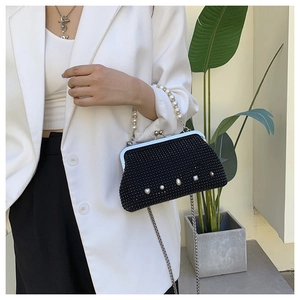 Detail of black rhinestone evening bag with heart pearls and metal chain strap
