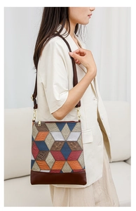 Close-up of geometric patchwork handbag featuring multi-textured PU leather and gold hardware